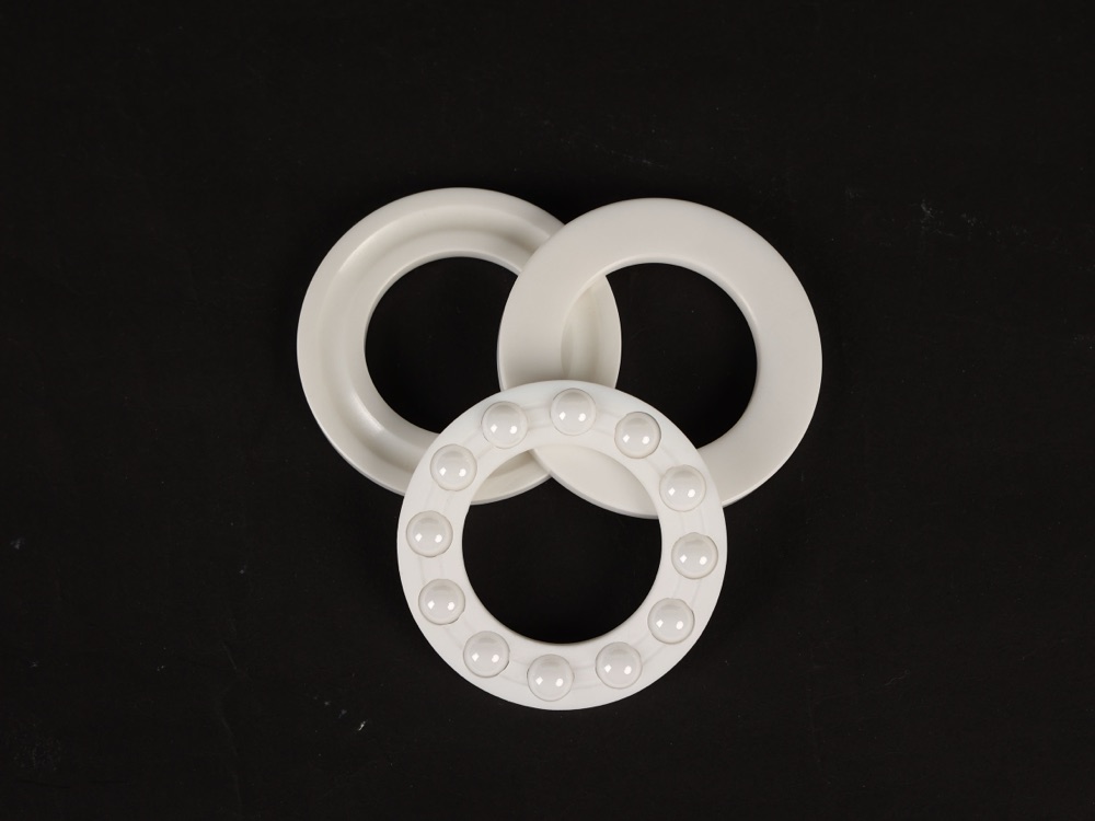 Ceramic thrust ball bearing washers and ball cage on dark background